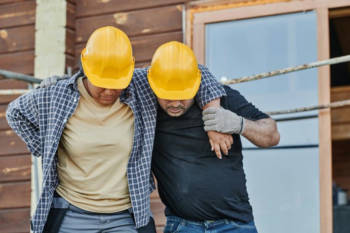 manager holding his injured coworkers and helping him walk 